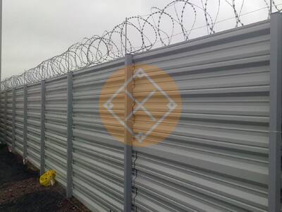 Забор из горизонтального профнастила с колючей проволокой